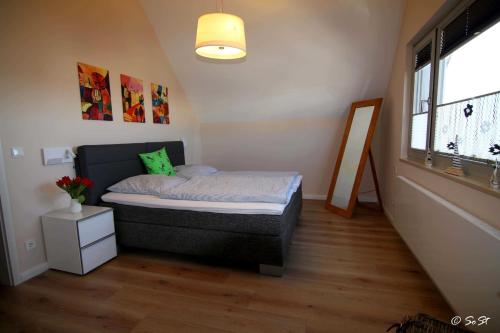 a small bedroom with a bed and a window at Ostsee - Reetdachhaus Nr 9 "Emma" im Strand Resort in Heiligenhafen