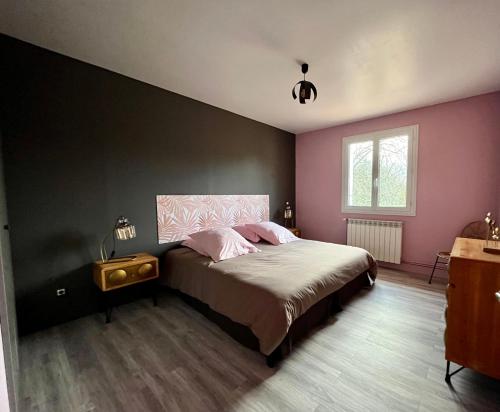 ein Schlafzimmer mit einem großen Bett mit rosa Wänden in der Unterkunft Gîte à l’orée du pré in Villiers-Saint-Benoît
