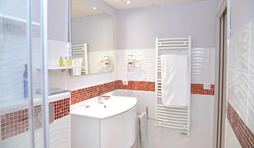 Baño blanco con lavabo y espejo en Les Chambres de Montplaisir, en Marsillargues