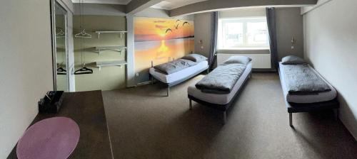 a room with two beds and a window at Hostel Fehmarn Mehrbett-Zimmer in Fehmarn