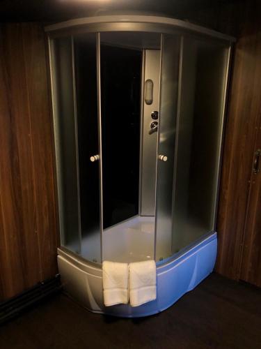 a glass shower with two towels in a room at Кузня міні-готель СПА ЗОНА та сніданки входять у вартість in Mateyevtsy