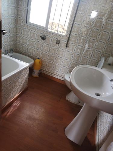 y baño con lavabo, bañera y aseo. en Casa completa, en Lugo