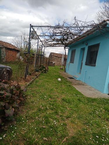 una casa azul con un patio de césped al lado en Casa completa, en Lugo