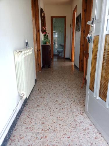 pasillo con suelo de baldosa y radiador en Casa completa, en Lugo