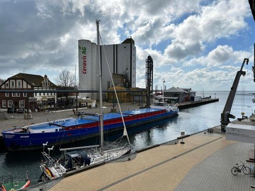 a boat is docked at a dock in the water at Hostel Fehmarn Ferienwohnung in Fehmarn