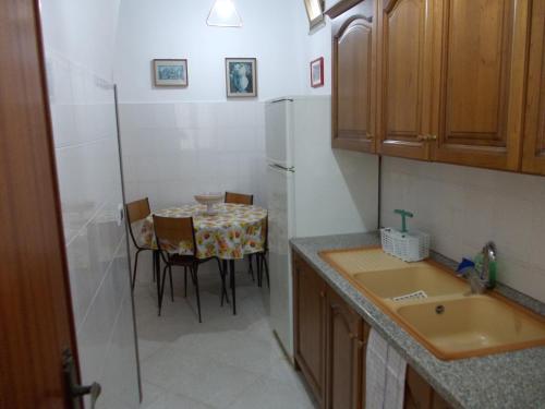 a small kitchen with a table and a refrigerator at Soleli in Molino San Biagio