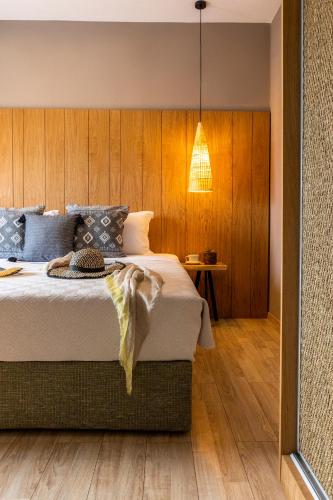 a bedroom with a bed with a wooden wall at Skiathos Theros, Philian Hotels and Resorts in Skiathos Town