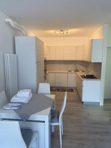 a kitchen with a table and chairs and a kitchen with white cabinets at Martin House in Pergine Valsugana