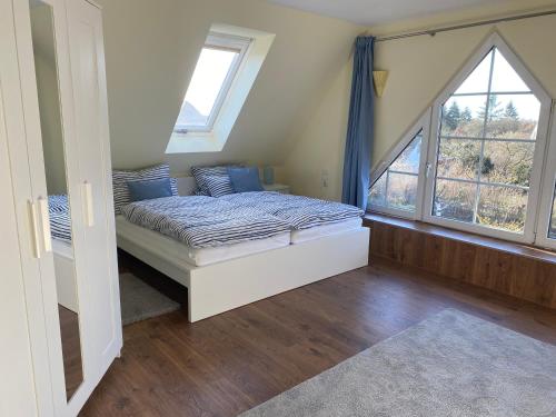 a bedroom with a bed and two windows at Stilvolle Ferienwohnung in der Nähe von Schwerin in Dümmer
