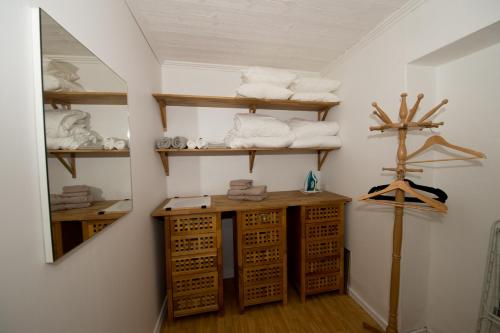 a bathroom with wooden shelves and towels on a wall at Naturskönt boende nära Skövde in Skövde