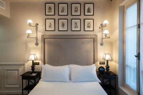 a hotel room with a bed, lamps and a lamp post at Hotel Saint-Louis en L'Isle in Paris