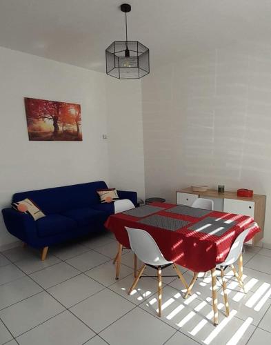 - un salon avec une table et un canapé bleu dans l'établissement Gite La Revinoise, à Revin