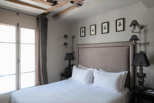 a bedroom with a large bed with white pillows at Hotel Saint-Louis en L'Isle - Notre-Dame in Paris
