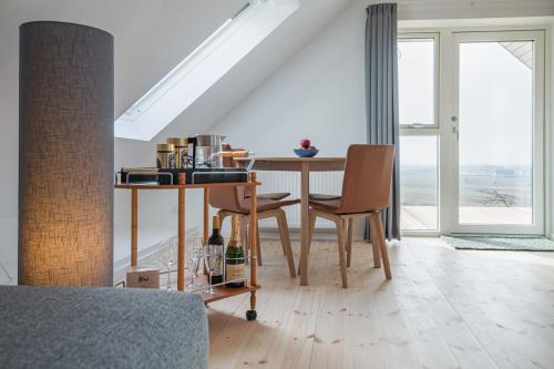 a dining room with a table and chairs and a window at Hotel Højgaarden in Slettestrand