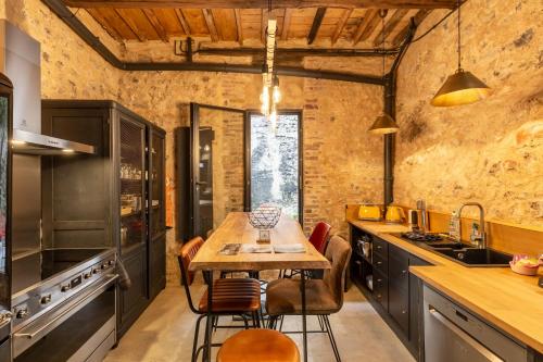 L'Atelier d'Eléa - 4 - Terrace - Indus-chic in the heart of Honfleur - 6 P في أونفلور: مطبخ مع طاولة وكراسي خشبية
