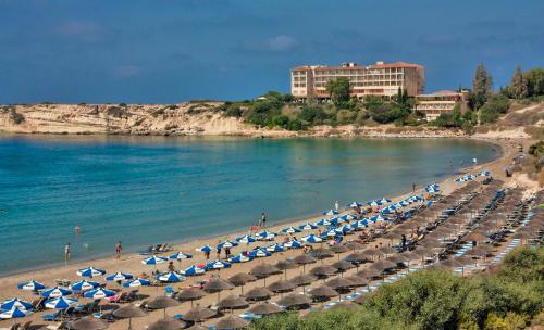 King Philips في Paphos: شاطئ به كراسي ومظلات ومحيط
