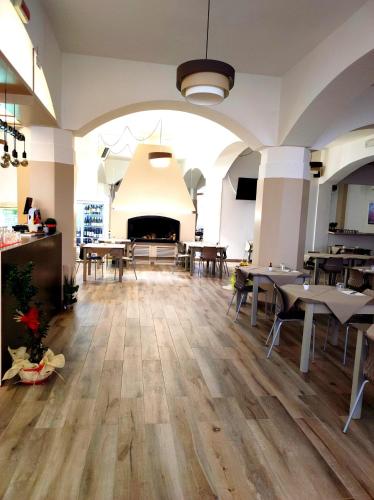 a large room with tables and a fireplace at Hotel Touring in Falconara Marittima