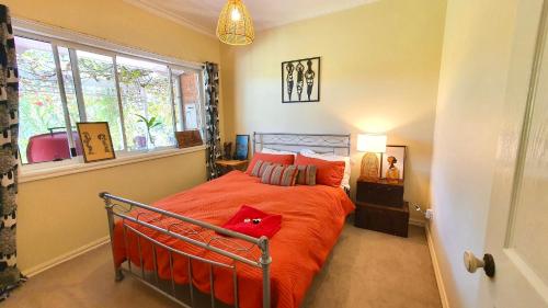 un dormitorio con una cama con un animal de peluche rojo en Belkampar Retreat - Authentic Farm Style Home - Perfect For Families and Large Groups!, en Bonnie Doon