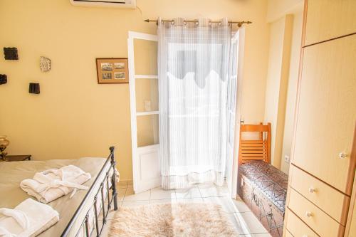 a bedroom with a bed and a window at La belle Hélène in Spetses