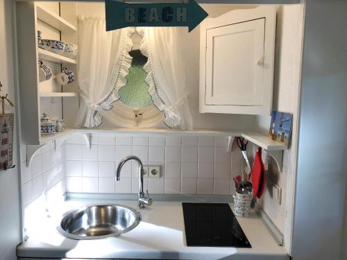 a small kitchen with a sink and a window at Bungalow "Prinz" in Nebel