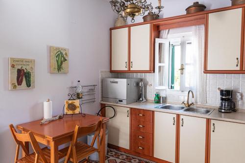 a kitchen with a table and a sink and a microwave at La belle Hélène in Spetses
