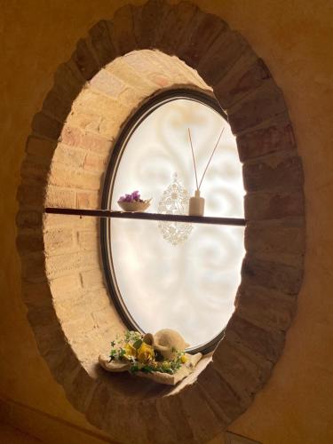 a round window in a brick wall with a bowl of flowers at Villa Civita in Colonnella