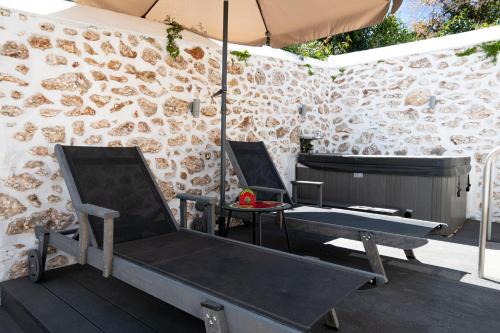 two chairs and a table with an umbrella on a patio at La belle Hélène in Spetses
