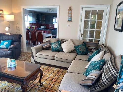 a living room with a couch and a table at Seascape on the edge of town: 4 beds all ensuite. in Belmullet