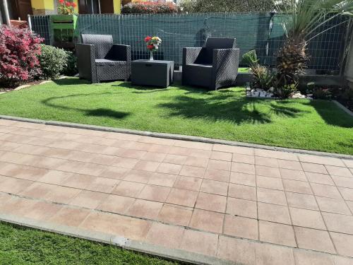 a patio with chairs and grass in a yard at Casa Maria in Cigole