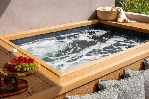 a hot tub in a wooden box on a table with fruit at Skiathos Avaton Suites & Villas, Philian Hotels and Resorts in Megali Ammos