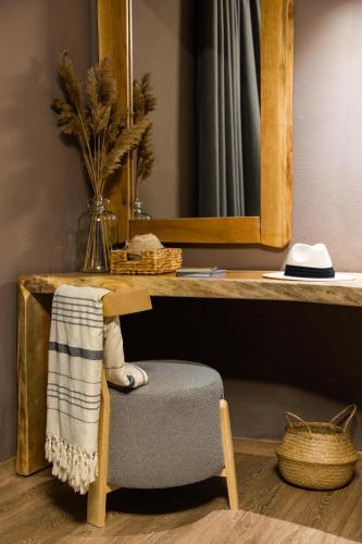a chair sitting under a desk with a mirror at Skiathos Avaton Suites & Villas, Philian Hotels and Resorts in Megali Ammos