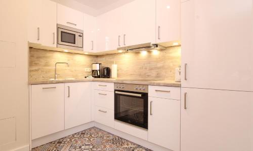 a white kitchen with white cabinets and a sink at Ferienwohnung Ines in Kühlungsborn