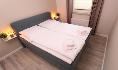 a bed with white sheets and pillows in a room at Ferienwohnung Ines in Kühlungsborn