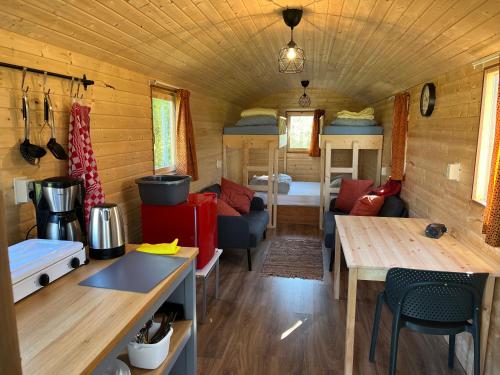 eine Küche und ein Wohnzimmer eines winzigen Hauses in der Unterkunft Pipowagen voor 4 personen in Diever