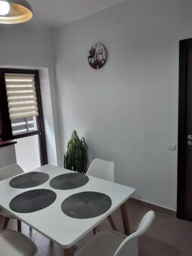 a white dining room with a white table and chairs at Residence SINAIA Apartments in Sinaia