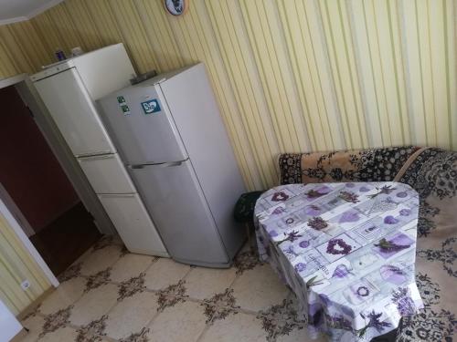 eine Küche mit zwei Kühlschränken, einem Sofa und einem Stuhl in der Unterkunft Eleon in Uman