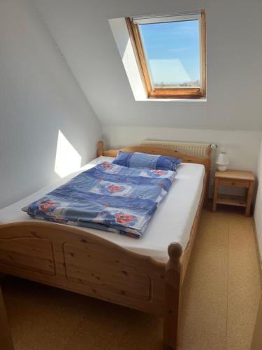 Dormitorio pequeño con cama y ventana en Landhaus Heyken, en Werdum