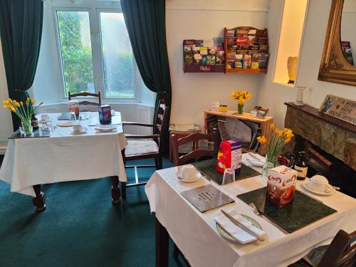 a dining room with two tables and two chairs at Arches B&B in St Austell