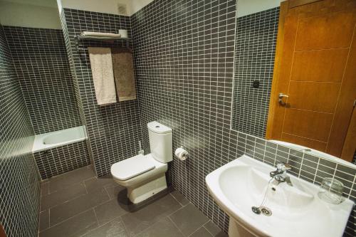 a bathroom with a white toilet and a sink at Hotel Rural el Pasil in Serradilla del Llano