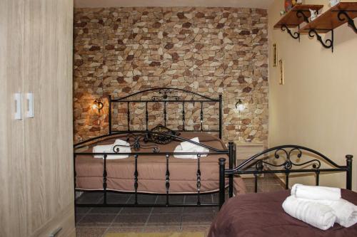 a bedroom with a bed and a brick wall at Apartment Timpirussimare in Sciacca