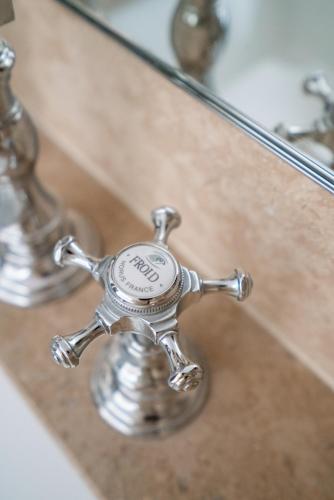 a silver sink faucet in front of a mirror at Hotel Saint-Louis en L'Isle - Notre-Dame in Paris
