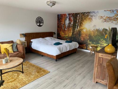 een slaapkamer met een bed en een bank bij De Veluwse bos Lodge in Otterlo