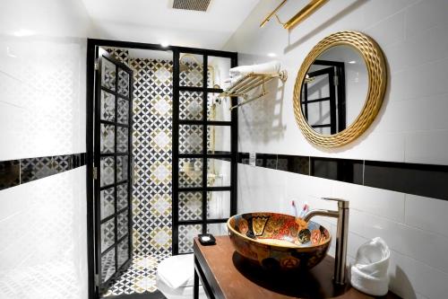 a bathroom with a bowl on a counter and a mirror at RARE Heritage House in George Town