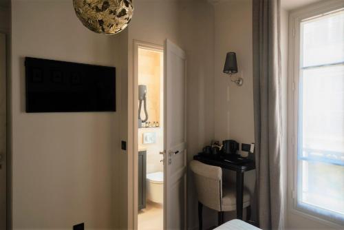 a bathroom with a sink, toilet and a window at Hotel Saint-Louis en L'Isle in Paris