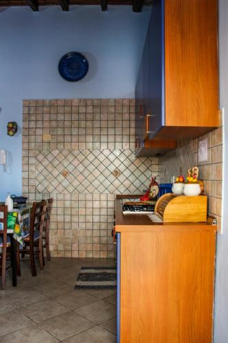 a kitchen with wooden cabinets and a counter top at Apartment Timpirussimare in Sciacca