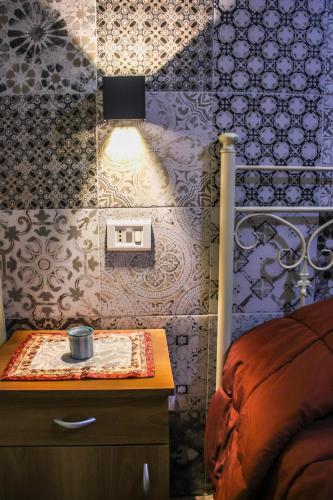 a bedroom with a table with a light on a wall at Apartment Timpirussimare in Sciacca