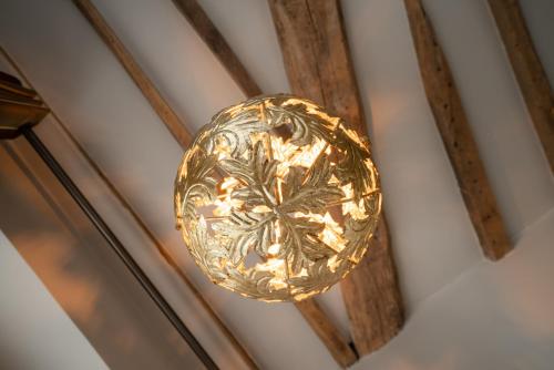 a gold pendant light hanging on a wall at Hotel Saint-Louis en L'Isle - Notre-Dame in Paris