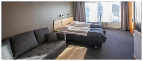 a living room with two beds and a couch at Laponia Hotell & Konferens in Arvidsjaur
