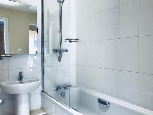 a white bathroom with a sink and a shower at The Bird in Hand in Ashwellthorpe