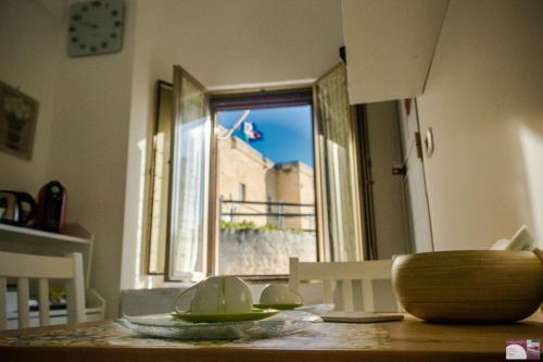 a dining room table with a view of a window at La loggetta 63 in Palagianello